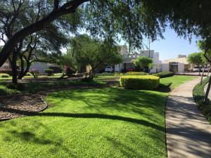 a park with green grass and trees and a sidewalk at House in Private Residential Development Globo-Outlets-Airport in León