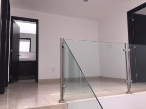 a glass staircase in a room with a mirror at House in Private Residential Development Globo-Outlets-Airport in León +12 photos
