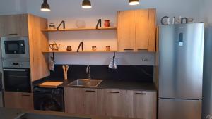 a kitchen with a stainless steel refrigerator and wooden cabinets at Casa Caldereta in Ayelo de Rugat