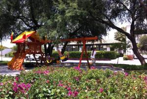 a park with a playground with a swing at House in Private Residential Development Globo-Outlets-Airport in León