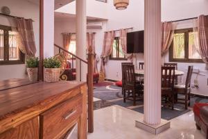 a living room with a table and a tv at Elegante villa avec Pool et près de la mer in Mbour