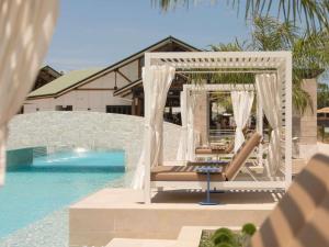 a pool with a gazebo and chairs next to the water at Novotel Darwin Airport in Darwin