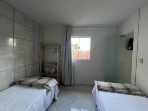een kamer met twee bedden en een raam bij Recanto Canuto D in Diamantina