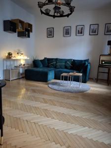 a living room with a blue couch and a table at Central Modern Studio - wifi, coffee in Bratislava