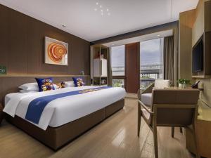 a large bedroom with a large bed and a desk at Novotel Shanghai Clover in Shanghai