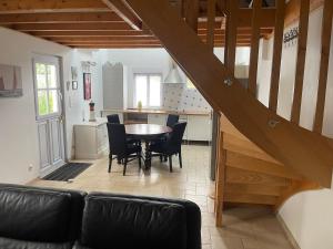 a living room with a table and chairs and a kitchen at Les Dunes de Longchamp in Saint-Lunaire