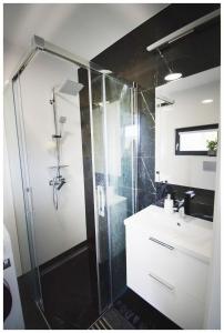 a bathroom with a shower and a sink at Biała chatka w Krzaczastym Zakątku 