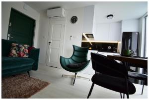 a living room with a green couch and a table and chairs at Biała chatka w Krzaczastym Zakątku  +8 photos