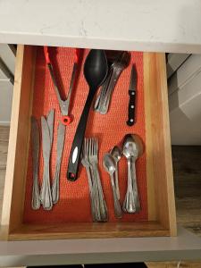 een lade gevuld met keukengerei in een houten doos bij Entire Spacious House in New Jersey in East Orange