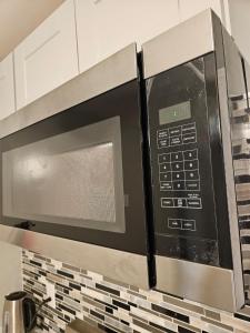 a microwave oven over a stove in a kitchen at Entire Spacious House in New Jersey in East Orange +16 photos