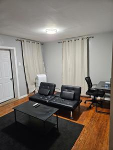 een woonkamer met een zwarte bank en een tafel bij Entire Spacious House in New Jersey in East Orange +16 foto's