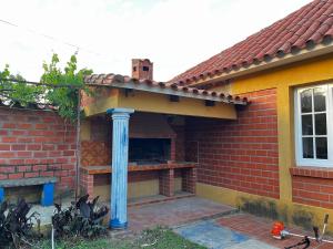 een bakstenen huis met een buitenhaard met een blauwe paal bij Brisas del Cadillar in Tarija +2 foto's