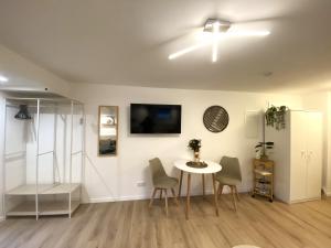 a living room with a table and chairs and a tv at Allgäu-Nest mit Stellplatz in Durach