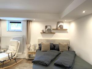 a bedroom with a bed and a chair and a window at Allgäu-Nest mit Stellplatz in Durach