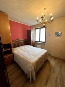 a bedroom with a bed and a chandelier at Holiday PratoNevoso - Sci ai piedi in Prato Nevoso
