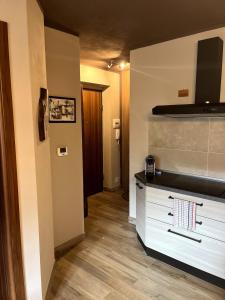 a kitchen with a white dresser and a hallway at Holiday PratoNevoso - Sci ai piedi in Prato Nevoso