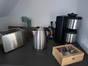 uma bancada com comodidades para preparar café e uma torradeira em DESIGN-LOFT Brockenblick -Netflix-Smart TV-WLAN-Wallbox-Kaffeevollautomat-Balkon- Panoramaaussicht-Getränke-Pizza-Snacks em Wernigerode