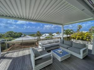 a patio with a couch and a table on a deck at GPSA83 - 8 pax in Fouché