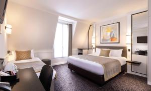 a hotel room with a bed and a desk at Elysées Union in Paris +100 photos
