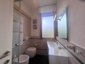 a bathroom with a sink and a toilet and a window at Appartamento vista mare in Castiglioncello
