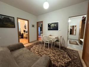 a living room with a couch and a table and chairs at Retro apartment with three rooms in Bratislava
