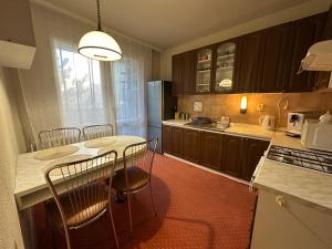 a kitchen with a table and chairs and a refrigerator at Retro apartment with three rooms in Bratislava