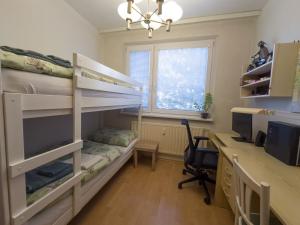 a bedroom with bunk beds and a desk with a computer at Retro apartment with three rooms in Bratislava