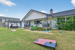 une maison avec un drapeau américain sur la pelouse dans l'établissement Walk to Lake Texoma Family-Friendly Retreat, à Willow Spring