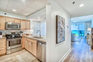 a kitchen with wooden cabinets and stainless steel appliances at HP 15W Salt and Light by 30A Escapes in Rosemary Beach
