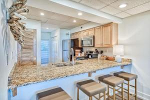 a kitchen with a counter and stools in a room at HP 15W Salt and Light by 30A Escapes in Rosemary Beach +18 photos