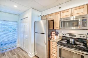 a kitchen with stainless steel appliances and wooden cabinets at HP 15W Salt and Light by 30A Escapes in Rosemary Beach