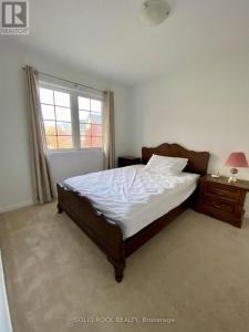 Un dormitorio con una cama y una ventana en Cozy Prime Home, en Ottawa