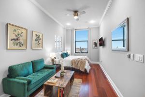 een woonkamer met een groene bank en een bed bij Luxury Studio Loft Rooftop View & Pool in Philadelphia
