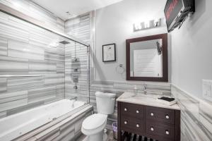 een badkamer met een bad, een toilet en een wastafel bij Luxury Studio Loft Rooftop View & Pool in Philadelphia