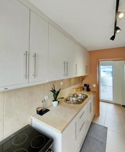 eine Küche mit weißen Schränken und einer Spüle in der Unterkunft Douro Valley Private Terrace & Lounge in Armamar