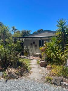 a house with palm trees in front of it at First Light in Mangawhai
