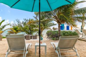 two chairs and an umbrella on the beach at The Sand Dollar at Cottages in Sand Bluff