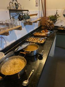 a kitchen with many pans of food on a counter at Hotel Fazenda Vitoria in Pindorama
