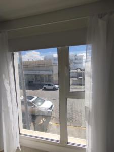 ein Fenster mit einem Auto auf einem Parkplatz in der Unterkunft Departamento Céntrico in Río Grande