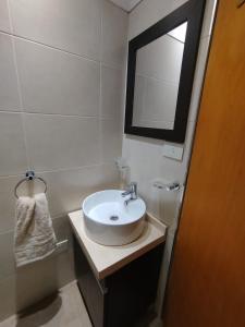 ein Badezimmer mit Waschbecken und Spiegel in der Unterkunft Departamento Céntrico in Río Grande