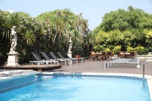 a swimming pool with lounge chairs and a table and a pool at Augusta Club & Spa - Adults Only in Lloret de Mar