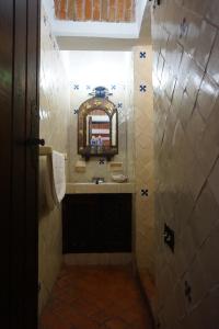 a small bathroom with a sink and a mirror at Suites Poza Real in Tequisquiapan