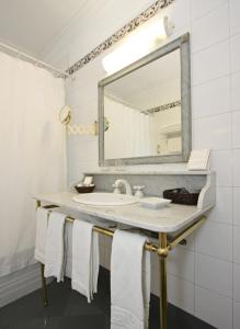 a bathroom with a sink and a mirror and towels at Solar De La Plaza in Salta