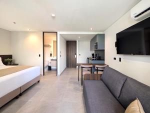 メデジンにあるLaureles Selection Suitesのベッドとソファのあるホテルの部屋