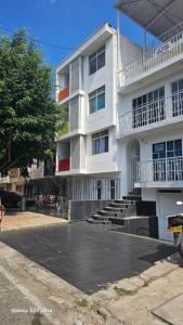 a white building with a parking lot in front of it at Mi dushi in Cali