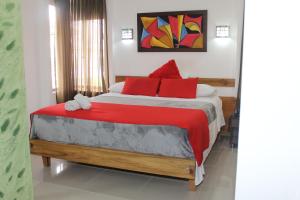 a bedroom with a large bed with red pillows at HOTEL NOGAL PLAZA in La Virginia