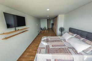 a room with two beds and a flat screen tv at Modern loft and parking ideal for couples in Acacías