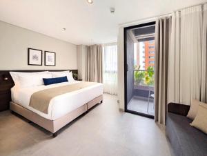 メデジンにあるLaureles Selection Suitesの大きなベッドとソファのある寝室