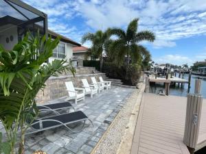 マルコ・アイランドにある"The Lighthouse" l Gorgeous Waterfront 3 Bed with Quick Access to Gulfの水辺のパティオに置かれた白い椅子のグループ