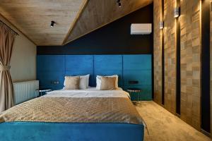 a bedroom with a large bed with a blue headboard at Greitser Elit Chalet in Bukovel